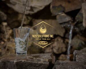 A glass sitting on rocks being filled with water from outside