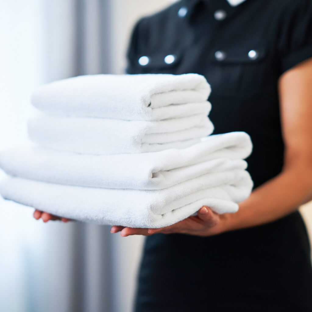 Image of a hotel maidservice bringing out clean folded towels